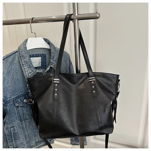 Detail der schwarzen Shopper-Tasche mit silbernen Sternnieten und Lederstruktur
