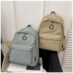 Detailed view of durable nylon backpacks in light blue and khaki with circular branding