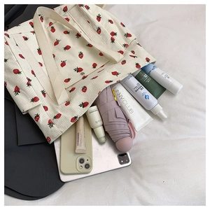 Dettaglio della borsa tote in velluto a coste color crema con fragole e grande spazio