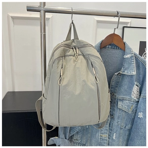 Detail of light grey-green waterproof nylon backpack with front vertical zip pockets