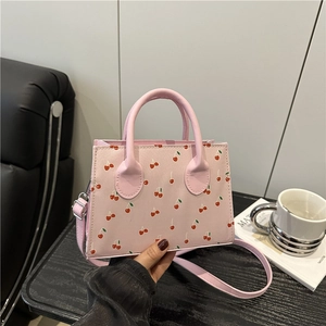 Pink cherry print crossbody bag with dual handles and adjustable shoulder strap