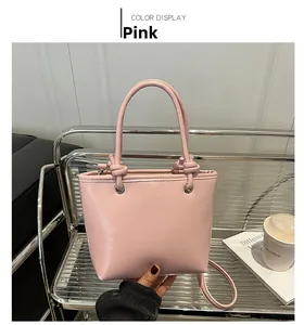 Detail of pink leather bucket bag with knot handle and elegant metal ring hardware