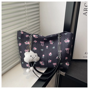 Detail of floral tote bag featuring 3D pleated texture and silver chain strap