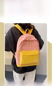 Detail of pink polka dot backpack with yellow contrast pocket and white rope zipper pulls