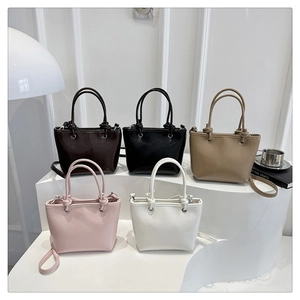 Detail of minimalist bucket bags in five colors with leather handles and straps