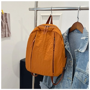 Detailed macro view of orange nylon backpack texture with double zipper and front pockets
