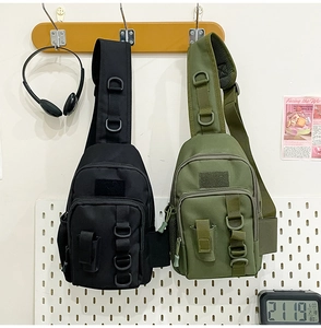 Detail of tactical shoulder bags in black and army green with D-rings and velcro patches