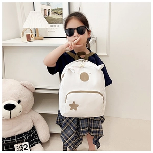 Close-up of white canvas toddler backpack featuring cute animal ears and a star patch