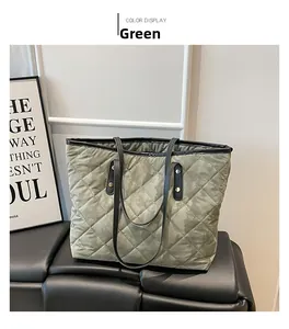 Detail of green quilted tote bag with diamond pattern and sturdy black shoulder straps
