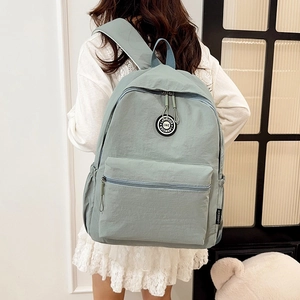Minimalist light greyish green campus backpack with a round logo and front zip pocket