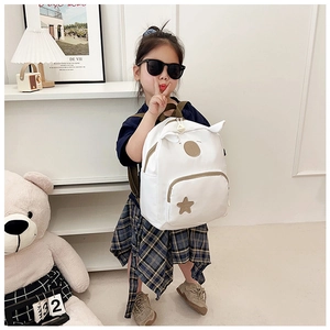 Detail of cute white canvas toddler backpack with star patches and 3D ear decorations