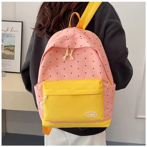 Detailed view of pink backpack with black polka dots and contrasting yellow straps
