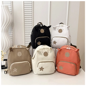 Detail showing five colorful cartoon kids backpacks with cute ears and star patches