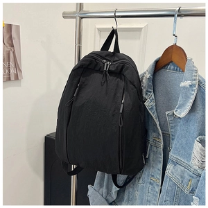 Close-up of black nylon backpack side pockets and durable zipper detail on casual bag