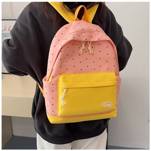 Detail of pink and yellow polka dot canvas backpack with front zipper pocket and Lolo tag