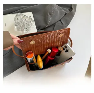 Brown woven texture handbag interior showing storage for phone and cosmetics