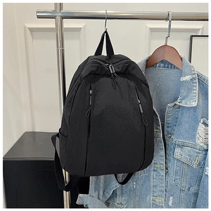 Detail view of black waterproof nylon backpack with functional dual zipper pockets