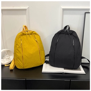 Front view of yellow and black minimalist nylon backpacks with vertical zipper pockets