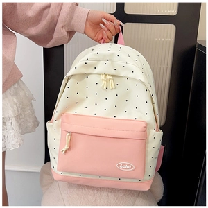 Close-up of pink front pocket and polka dot canvas on a sweet style student backpack