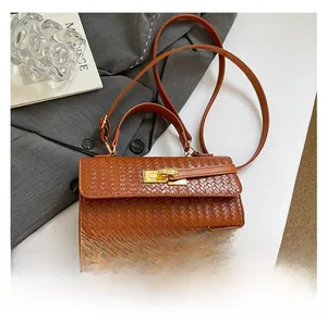 Detailed close-up of woven texture and gold metal buckle on a brown square handbag