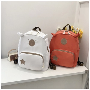 Detail view of cute animal ear backpacks in white and brick red with star patch design