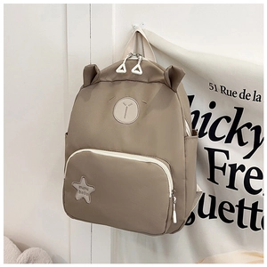 Detail view of khaki backpack with cute 3D ears and embroidered star patch pocket