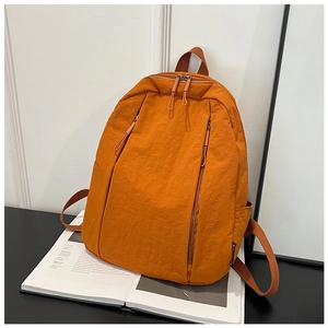 Detail view of water-resistant orange nylon backpack with functional vertical zippers