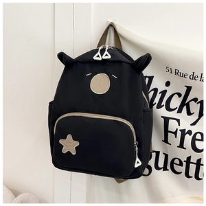 Detail of black canvas backpack with 3D ears, star patch and cute animal embroidery