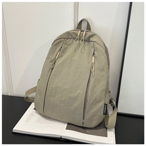 Close-up of lightweight nylon backpack featuring dual vertical zipper pockets and side tag