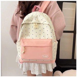 Rear view of model wearing the starry polka dot backpack with pink accents