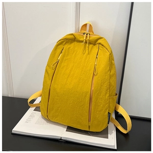 Detailed macro view of yellow nylon backpack fabric with subtle crinkle texture and logo