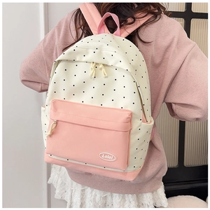 Detailed back view of pink and white polka dot backpack with adjustable straps and logo