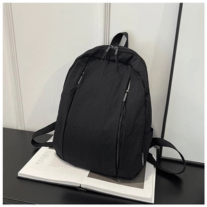 Detail view of black minimalist nylon backpack with side brand tag and vertical zippers