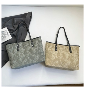 Close-up of quilted tote bags featuring rivet reinforcement and sleek faux leather handles