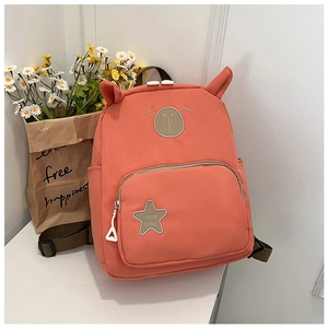 Close-up of cute coral pink kids backpack with bear embroidery and 3D animal ears design