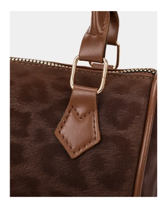 Detailed close-up of brown leopard print suede bucket bag with gold metal hardware