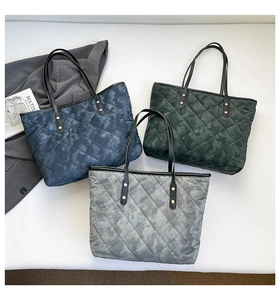 Three quilted tote bags in blue green and grey with camouflage texture and metal rivets