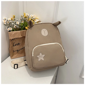 Detailed close-up of cute bear embroidery and animal ears on khaki nylon kids backpack