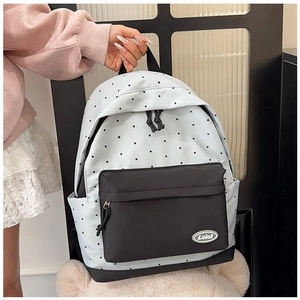 Detail of light blue polka dot backpack with front zipper pocket and logo branding