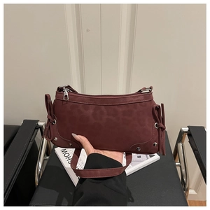 Detail view of burgundy faux suede hobo bag with side ribbons and silver hardware