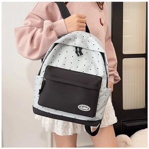 Detail view of stylish light blue polka dot backpack with black zipper pocket for students