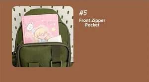 Detailed macro view of the front zipper pocket on a green canvas multifunctional sling bag