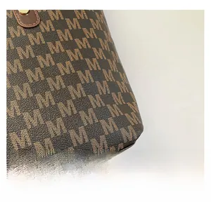 Close-up of vintage brown monogram pattern fabric and golden metal buckle on tote bag