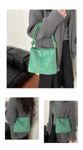 Détail du sac à main en daim vert avec texte tendance et poignée à nœud tissé