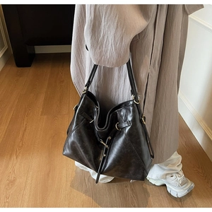 Detailed view of vintage large capacity leather tote bag with stylish metallic buckles