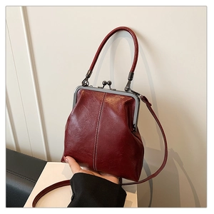 Détail du sac vintage bordeaux avec texture huilée et fermeture par fermoir doré