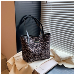 Close-up of leopard print tote bag with black leather Fashion logo tag on soft coat