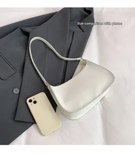 Detailed top view of a white hobo bag shown next to a smartphone for size reference