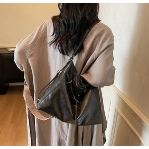 Detail of the high-quality black leather strap with metallic buckle on a vintage tote bag