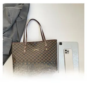 Macro view of tote bag details with bow hardware and digital device size comparison